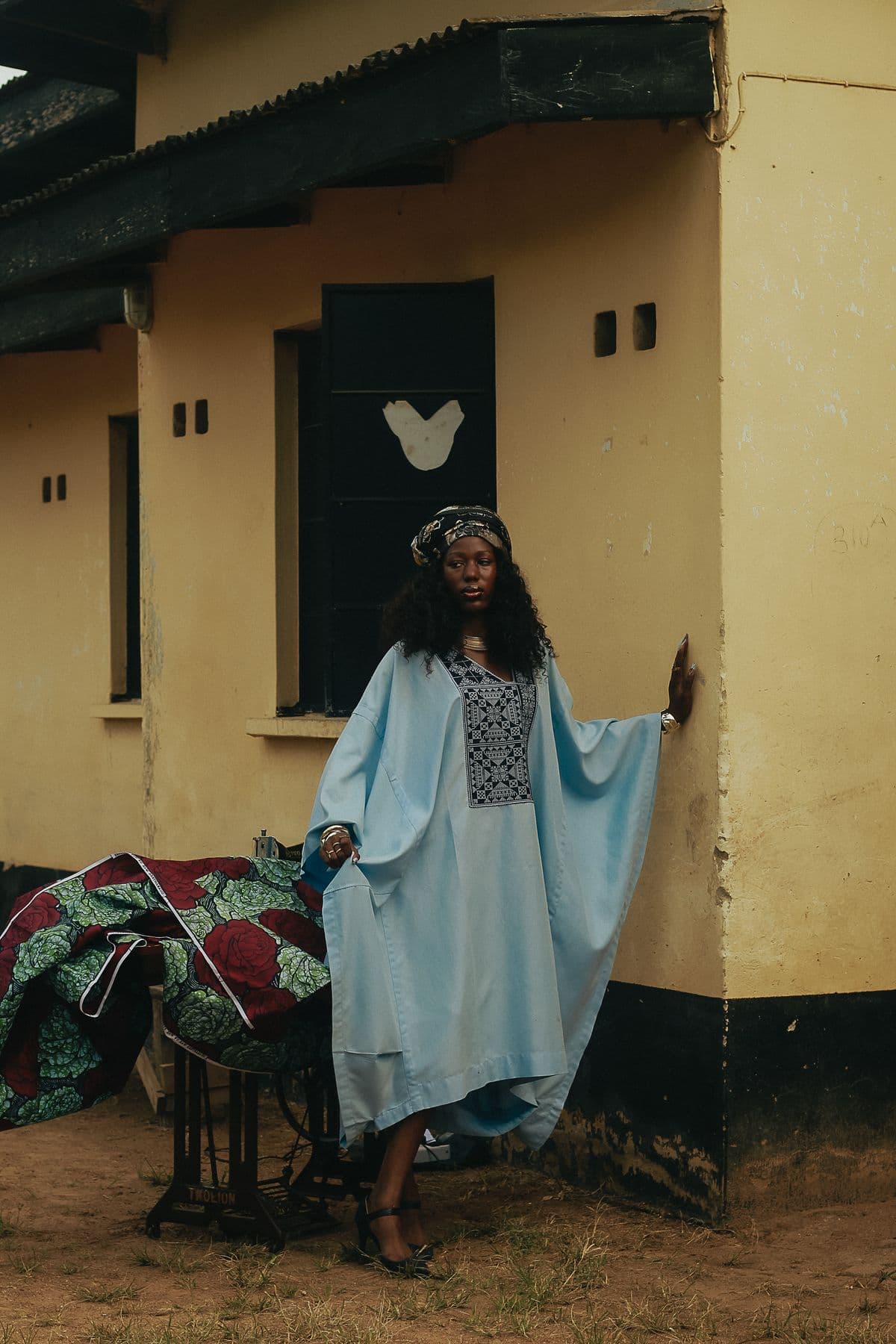 A designer at work in traditional dress beside a sewing machine
